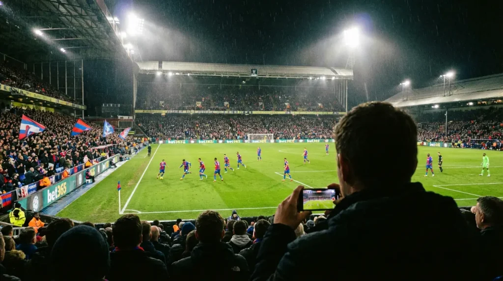 Tifoso che segue una partita di calcio dal vivo in uno stadio illuminato di sera